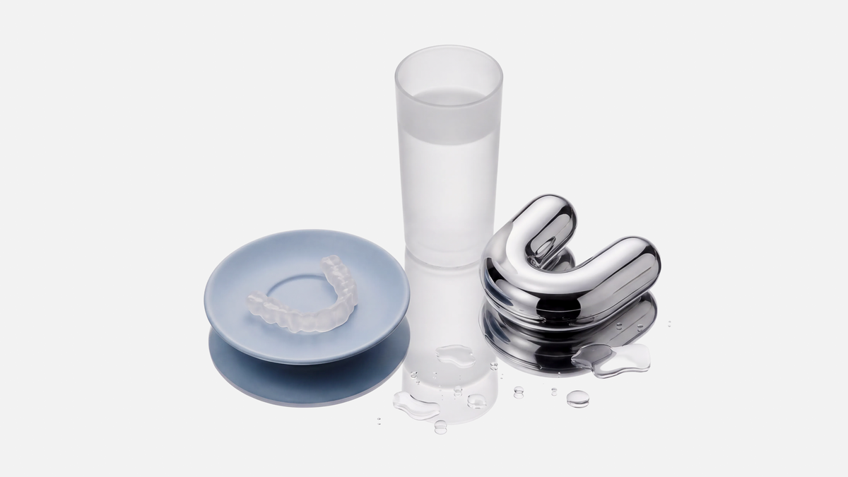 moses stainless steel case beside a glass and retainer on a blue plate